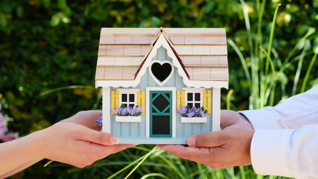pexels-photo-7578939-7578939 Close-up of hands holding a detailed miniature house model, symbolizing goals of homeownership.